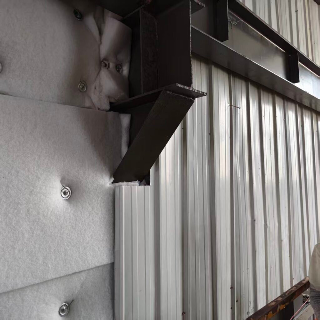 Acoustic wool cut and fitted around a steel beam bracket on a steel office wall